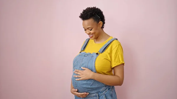 Junge Schwangere Frau Lächelt Zuversichtlich Anrührenden Bauch Über Isolierten Rosa — Stockfoto