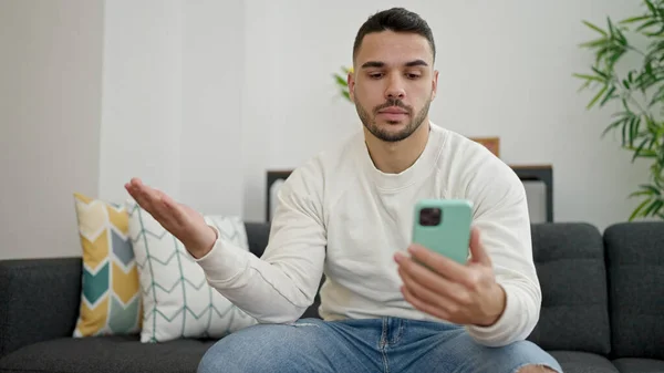 Young Hispanic Man Stressed Sitting Sofa Using Smartphone Home — Stock Photo, Image