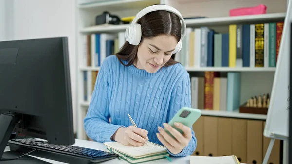 図書館大学でスマートフォンのノートを使っている若い白人女性学生 — ストック写真