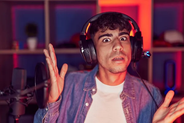 若いヒスパニック系の男がビデオゲームを叫んで大声で口の上に手で横に叫んでいる コミュニケーションの概念 — ストック写真