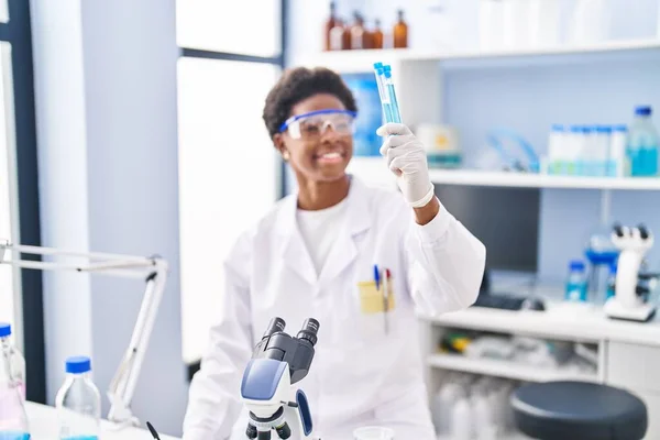 アフリカ系アメリカ人女性研究室でクリップボードの保持テストチューブ上の科学者の均一な書き込みを着て — ストック写真
