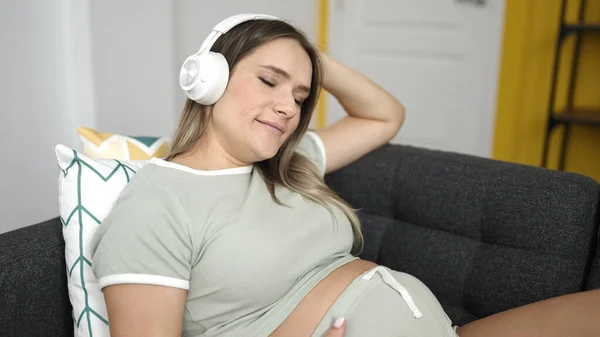 Ung Gravid Kvinna Lyssnar Musik Avslappnad Soffan Hemma — Stockfoto