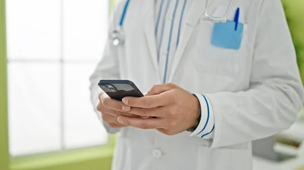 Young Hispanic Man Doctor Using Smartphone Clinic — Stock Photo, Image