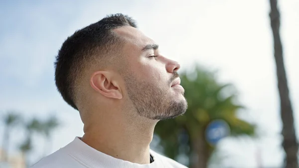 Stock image Young hispanic man breathing with closed eyes at street