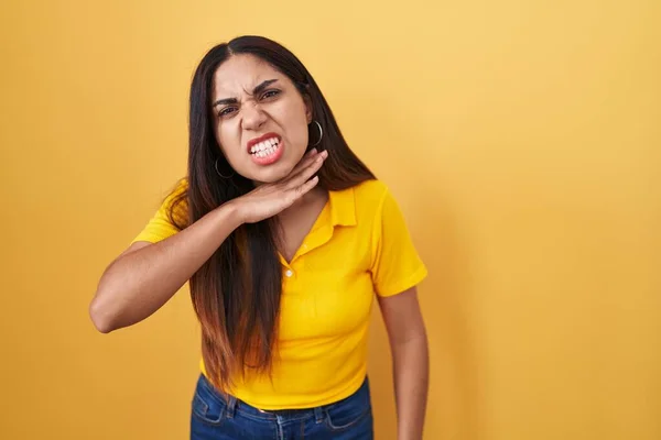 若いアラブの女性はナイフのように手で喉を切断黄色の背景に立って 激怒暴力で侵略を脅かす — ストック写真