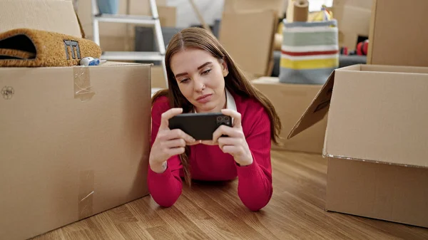 Jovem Hispânica Assistindo Vídeo Smartphone Deitado Chão Uma Nova Casa — Fotografia de Stock