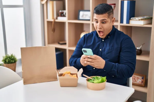 Hispanischer Junger Mann Der Mit Dem Smartphone Essen Zum Mitnehmen — Stockfoto