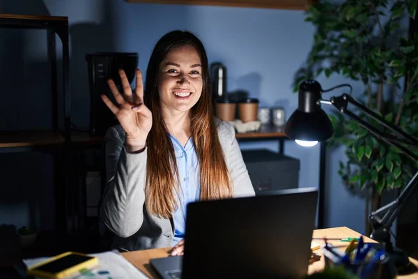 年轻的黑发女人晚上在办公室里工作时 露出并用第四指尖 面带微笑 自信而快乐 — 图库照片
