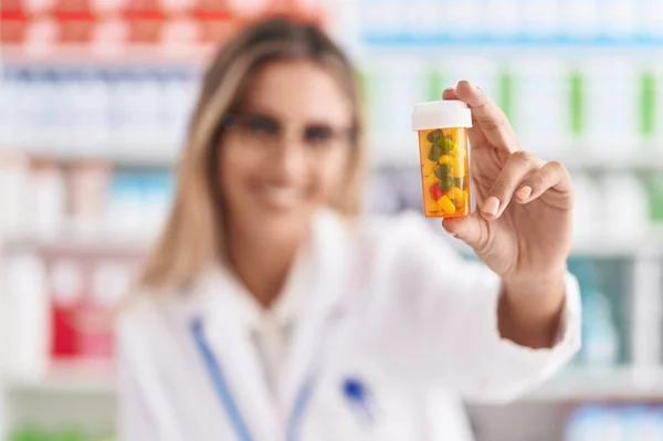 Young Blonde Woman Pharmacist Smiling Confident Holding Pills Bottle Pharmacy — Stockfoto