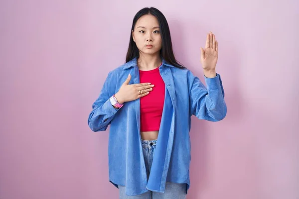 Mladá Asiatka Stojící Nad Růžovým Pozadím Nadávající Rukou Hrudi Otevřenou — Stock fotografie