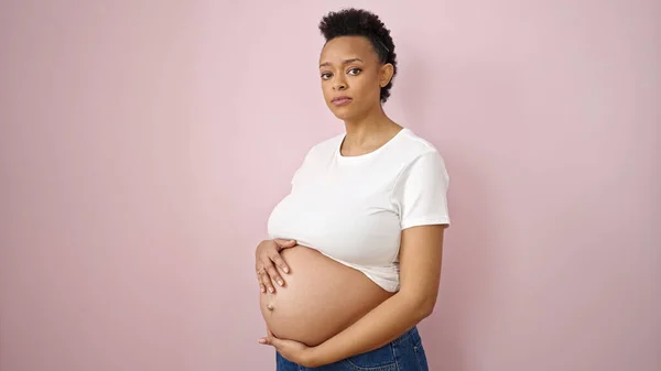 Junge Schwangere Frau Berührt Bauch Mit Entspanntem Ausdruck Über Isoliertem — Stockfoto
