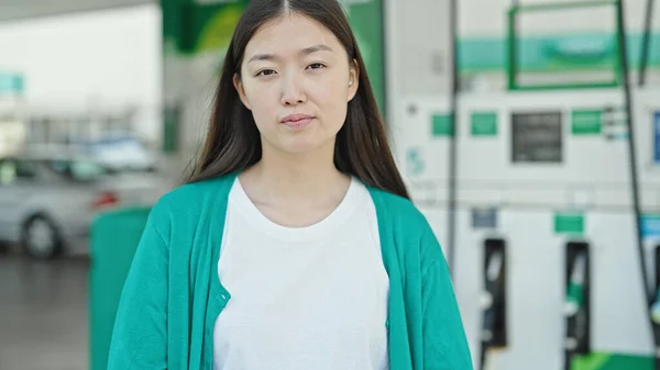 年轻的中国妇女站在加油站边严肃地看着 — 图库照片