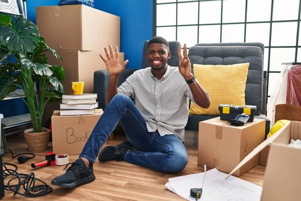 Hombre Afroamericano Sentado Suelo Casa Nueva Mostrando Señalando Con Los — Foto de Stock