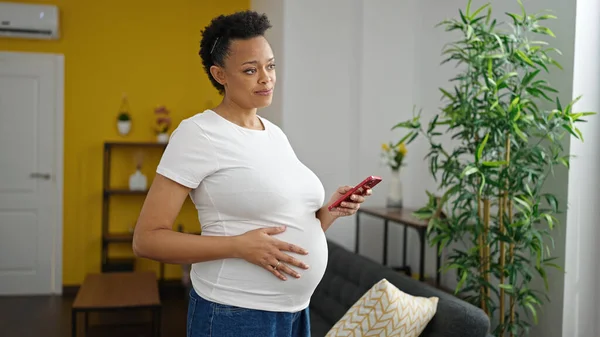 Ung Gravid Kvinna Med Smartphone Ler Hemma — Stockfoto