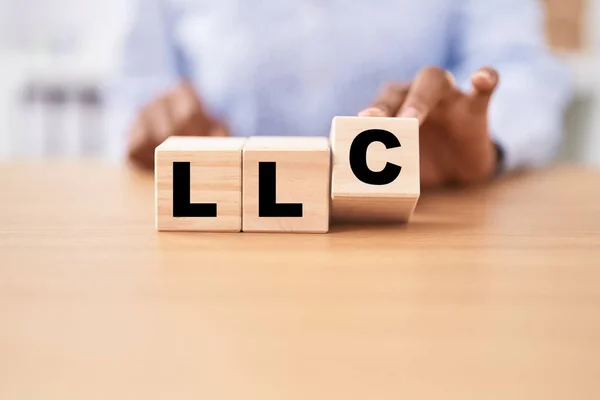 Black Woman Holding Cubes Llc Word Table — Stock Photo, Image