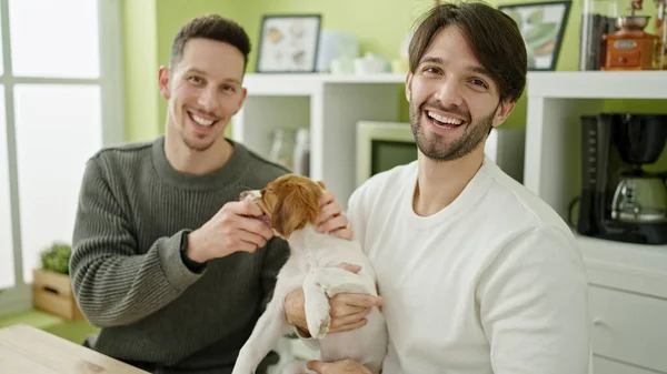 Dos Hombres Pareja Sonriendo Confiado Sentado Mesa Abrazando Perro Comedor — Foto de Stock