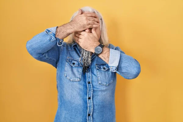 Мужчина Средних Лет Седыми Волосами Стоящими Жёлтом Фоне Закрывая Глаза — стоковое фото