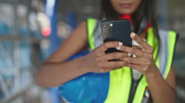 Sokakta akıllı telefon kullanan Afrikalı Amerikalı kadın müteahhit.