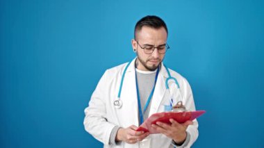 İspanyol doktor, mavi arka planda panoda belge okuyor.