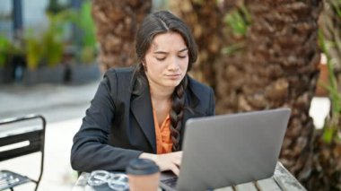 Genç, güzel, İspanyol bir iş adamı kahve dükkanının terasında akıllı telefon kullanarak işini bitiriyor.