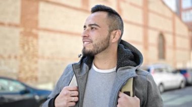 İspanyol adam gülümsüyor. Kendine güveniyor. Caddeye bakıyor.