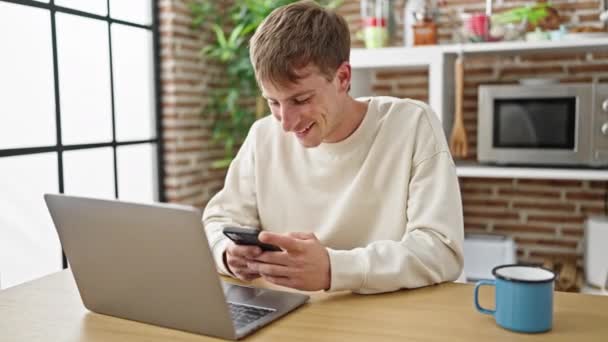 Hombre Caucásico Joven Usando Ordenador Portátil Teléfono Inteligente Comedor — Vídeos de Stock