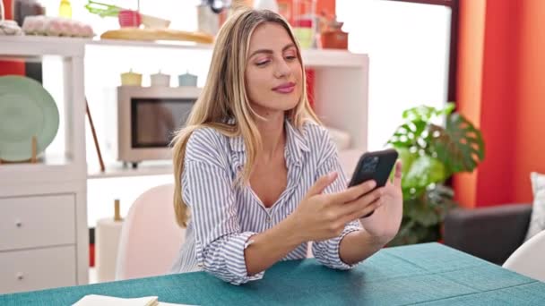 Νεαρή Ξανθιά Γυναίκα Που Χρησιμοποιεί Smartphone Κάθεται Στο Τραπέζι Στην — Αρχείο Βίντεο