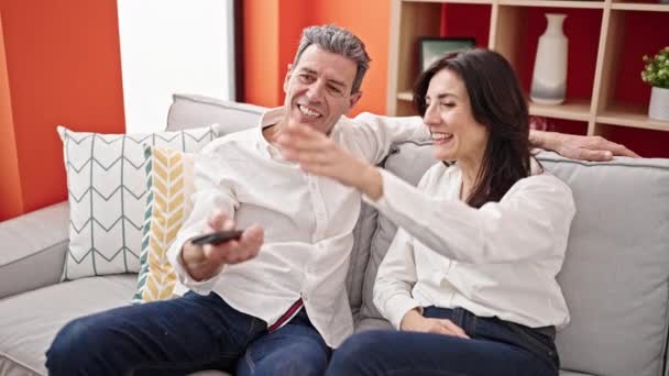Seniorenpaar Lächelt Zuversichtlich Und Kämpft Hause Fernbedienung Für Den Fernseher — Stockvideo