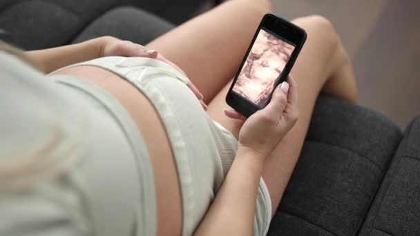 Молодая Беременная Женщина Трогает Живот Глядя Ребенка Ультразвук Дома — стоковое видео