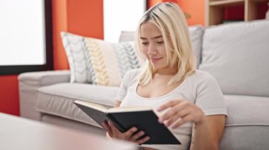 Genç ve güzel İspanyol kadın evde oturmuş kitap okuyor.