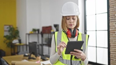 Ofiste ciddi bir ifadeyle dokunmatik kağıda resim çizen genç sarışın kadın mimar.