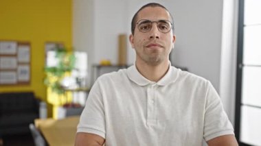 Genç İspanyol iş adamı ofiste kendinden emin gülümsüyor.