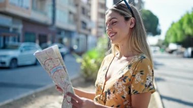 Genç sarışın kadın turist gülümsüyor. Kendine güvenen şehir haritası.