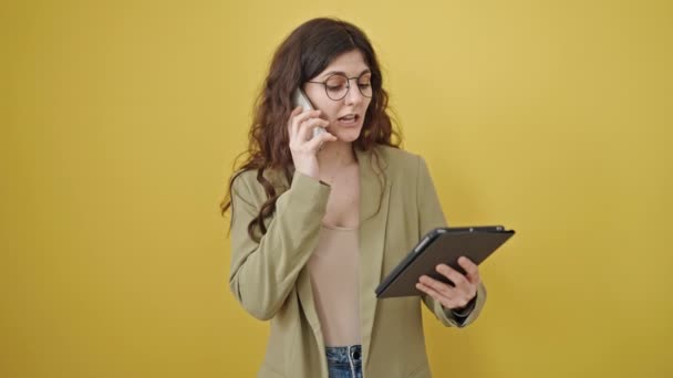 Ung Vacker Latinamerikansk Kvinna Med Pekplatta Talar Smartphone Över Isolerad — Stockvideo