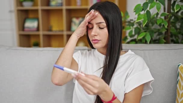 Junge Schöne Hispanische Frau Hält Schwangerschaftstest Mit Besorgtem Gesichtsausdruck Hause — Stockvideo