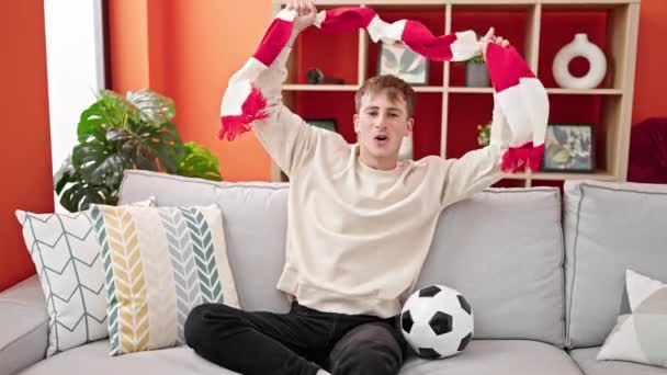 Młody Biały Mężczyzna Wspieranie Piłka Nożna Zespół Trzymając Szalik Domu — Wideo stockowe