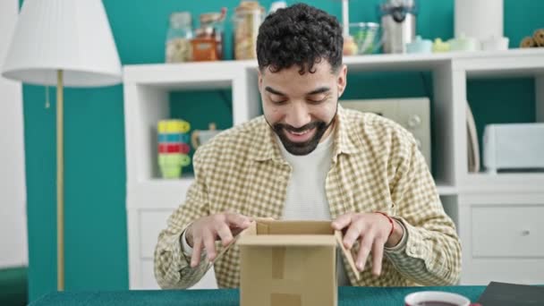 Jonge Spaanse Man Uitpakken Kartonnen Doos Met Winnaar Uitdrukking Eetkamer — Stockvideo