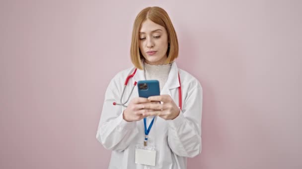 Młoda Blondynka Lekarz Uśmiecha Się Pomocą Smartfona Odizolowanym Różowym Tle — Wideo stockowe