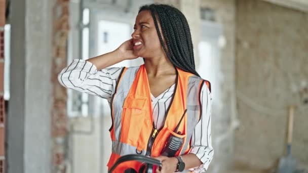 Afrikansk Amerikansk Kvinna Byggare Bär Hörlurar För Buller Byggarbetsplatsen — Stockvideo