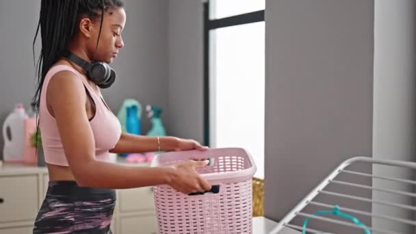 洗濯室でアフリカ系アメリカ人の女性が服を着て — ストック動画