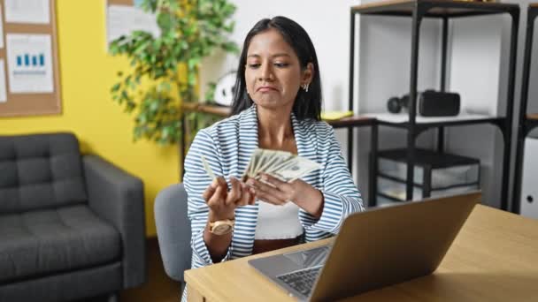 アフリカ系アメリカ人の女性ビジネスワーカーがオフィスでラップトップの数値ドルを使う — ストック動画