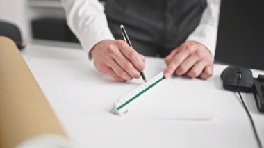 Genç İspanyol mimar ofiste ev planları çiziyor.