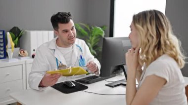 Kadın ve erkek doktor ve hasta klinikte tıbbi raporlarını gösteriyorlar.