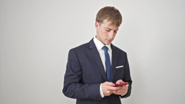 Kafkasyalı genç bir iş adamı, izole edilmiş beyaz arka plan üzerinden kazanan yüz ifadesine sahip akıllı telefon kullanıyor.