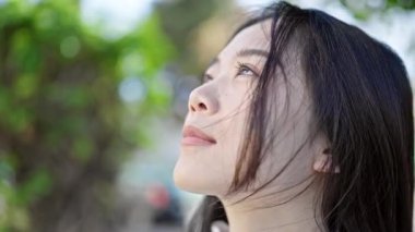 Young chinese woman breathing with closed eyes at park