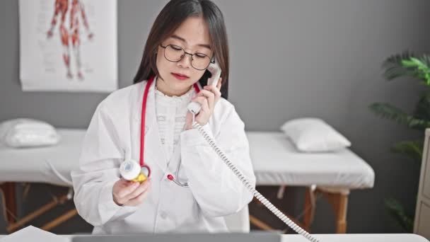 Young Chinese Woman Doctor Prescribe Pills Treatment Talking Telephone Clinic — Stock Video