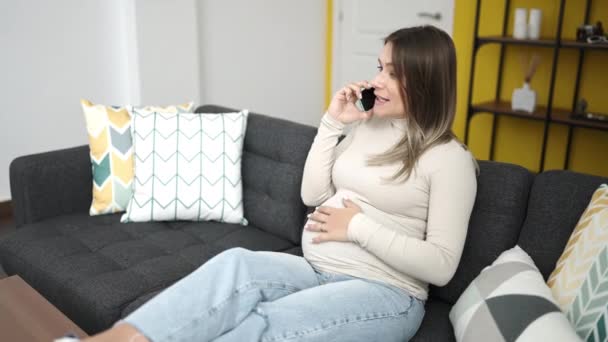 Молодая Беременная Женщина Разговаривает Смартфоне Касаясь Живота Дома — стоковое видео
