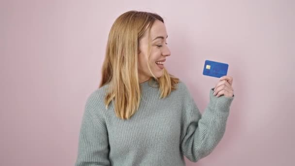 若いですブロンド女性笑顔自信を持って保持クレジットカードダンス上の隔離されたピンクの背景 — ストック動画