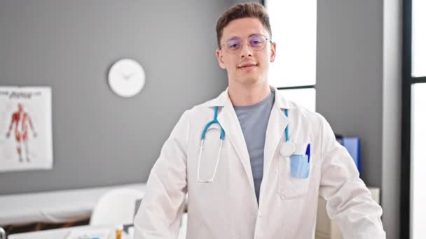 Tânăr Hispanic Bărbat Doctor Zâmbind Făcând Gestul Inimii Mâinile Clinică — Videoclip de stoc