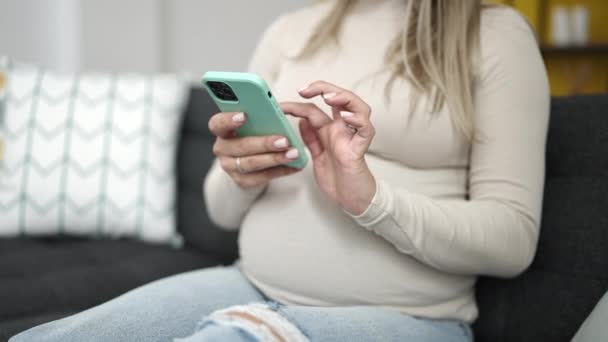 Mladá Těhotná Žena Pomocí Smartphone Dotýkání Břicho Doma — Stock video